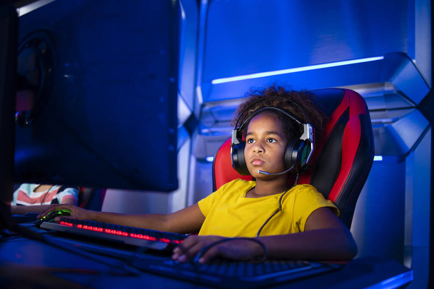Professional gamer wearing headset and playing online video game on computer. - Фото, зображення