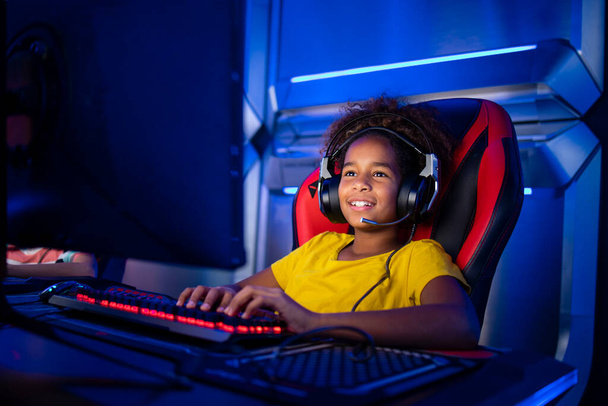 Kulaklık takan profesyonel bir oyuncu ya da bilgisayar üzerinden online video oyunları oynuyor. Eğlence sektörüne bağımlı çocuklar.. - Fotoğraf, Görsel