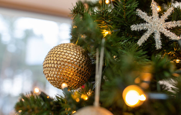 close up of golden ball on christmas tree - Fotó, kép