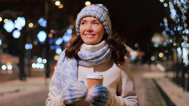 happy woman drinking coffee on christmas in city - Fotoğraf, Görsel