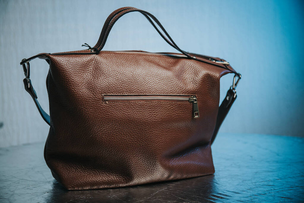 A closeup of a brown leather female handbag on a table - Foto, afbeelding
