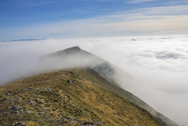 A daylight shot of mountains covered in heavy fog - Foto, imagen