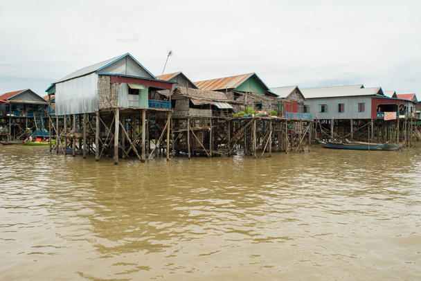 KAMPONG PHLUK, CAMBODIA - Aug 13, 2017: Wooden and metal houses and buildings built on stilts above the water of Tonle Sap lake in village of Kampong Phluk, Siem Reap, Cambodia, Asia - Fotoğraf, Görsel