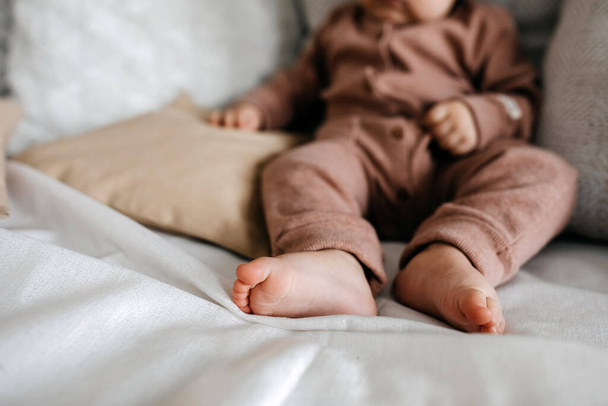 Closeup of baby barefoot feet on bed. - Photo, Image