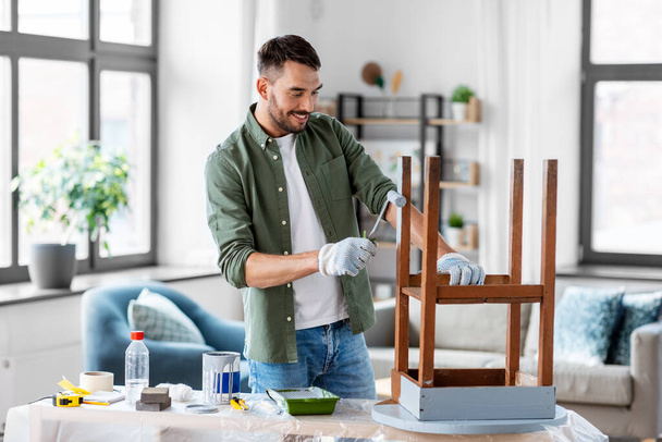 man painting old table in grey color at home - Foto, Bild