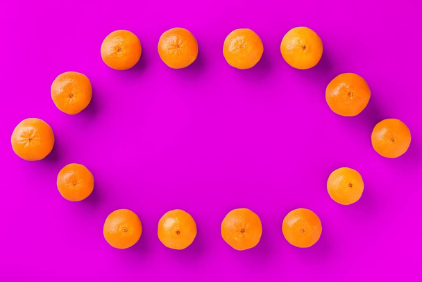 Fruit pattern of fresh orange tangerine or mandarin on lilac background. Flat lay, top view. Pop art design, creative summer concept. Citrus in minimal style. - Zdjęcie, obraz