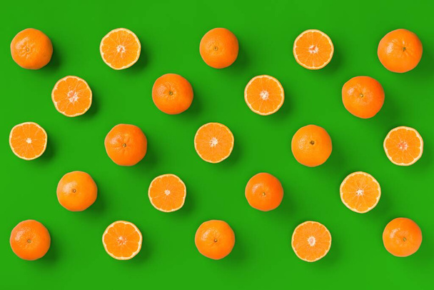 Фруктовый узор из свежего апельсинового мандарина или мандарина на зеленом фоне. Квартира лежала, вид сверху. Поп-арт дизайн, креативная летняя концепция. Цитрусовые в минимальном стиле
. - Фото, изображение