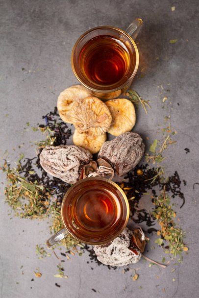φλυτζάνια τσάι και αποξηραμένα φρούτα από λωτούς και σύκα top view - Φωτογραφία, εικόνα