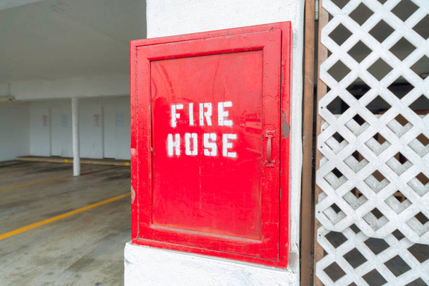 Vörös tűzoltó tömlő szekrény közel a parkolóhely ar Oceanside, California - Fotó, kép