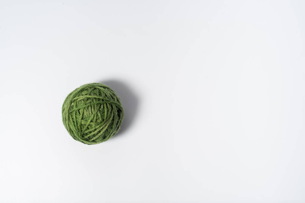 Single ball of dark green yarn on white background - Fotó, kép