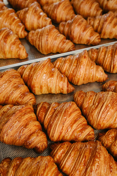 Frisch gebackene goldene französische Croissants auf Backblech. Frisches klassisches Gebäck. Nahaufnahme - Foto, Bild