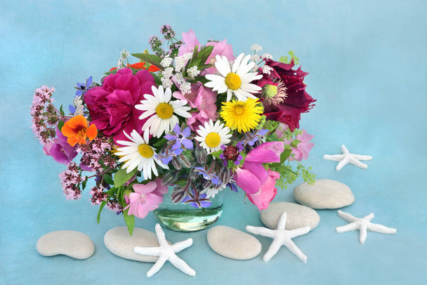 Αγγλικά καλοκαιρινά λουλούδια και βότανα με αστερίες και βότσαλα. Όλα τα φυτά που χρησιμοποιούνται σε φυτικά φυτικά φάρμακα για τη θεραπεία μιας ποικιλίας ασθενειών. Σύνθεση νεκρής μορφής σε μπλε φόντο. - Φωτογραφία, εικόνα