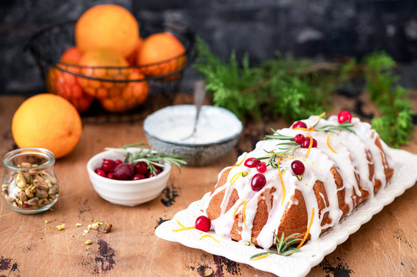 Traditional Christmas cake decorated with glaze,  cranberries and rosemary  - Photo, Image