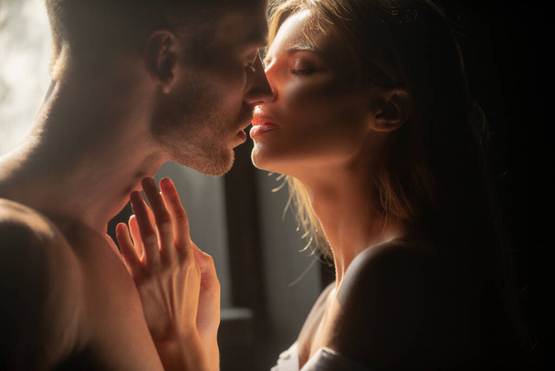 Portrait of lovely couple in love. Young sensual girlfriend glad to passionate kiss from her boyfriend. Handsome man embraces his woman and kisses. Sensual couple in the tender passion. - Foto, Imagem