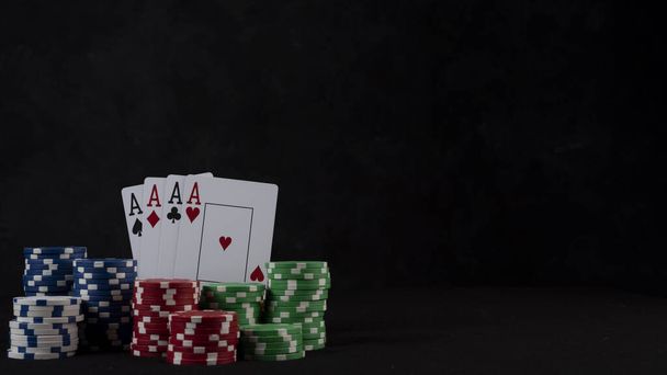 A closeup shot of poker chips and cards on a black background - Valokuva, kuva