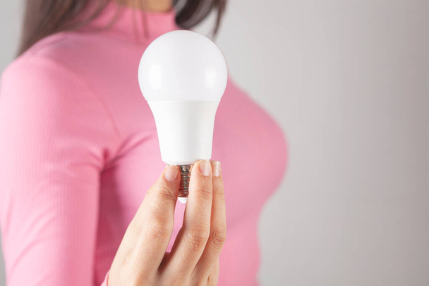 young woman holding a light bulb - Foto, Imagen