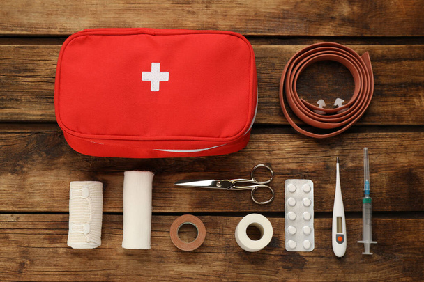 First aid kit on wooden table, flat lay - Fotoğraf, Görsel