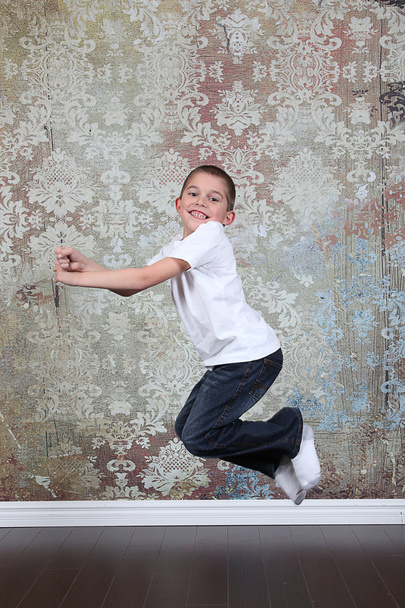 Little boy jumping in old empty room - Fotó, kép