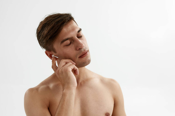 Man with closed eyes listening music in earphones - Fotó, kép