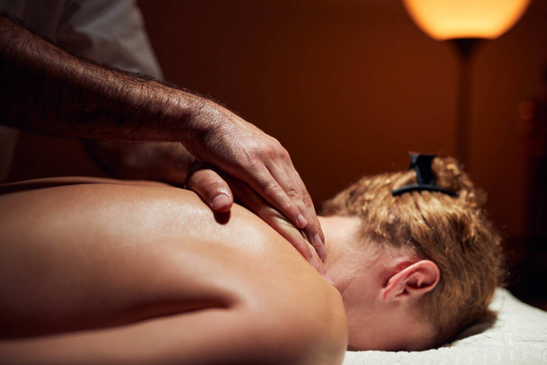 Frau auf einem Massagetisch, Chiropraktiker, Behandlung von Körper- und Hautverspannungen. - Foto, Bild