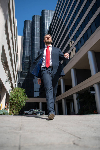 Business man walking on the street. Businessman walk near modern office center. Business success, step, boost personal career, and winning. - 写真・画像