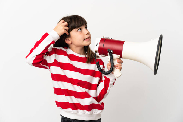 Маленькая девочка на белом фоне с мегафоном и сомнениями - Фото, изображение