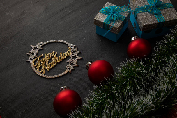 kultainen hyvää joulua merkki mustalla taustalla punaiset pallot ja lahjoja sininen keula. - Valokuva, kuva