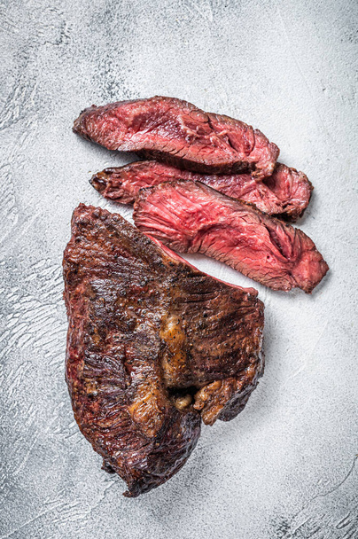 Roasted hanger or Onglet sliced beef meat steak on a table. White background. Top View - Photo, Image
