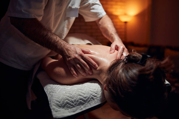 Woman on a massaging, chiropracting table, treatment of body and skin tension. - 写真・画像