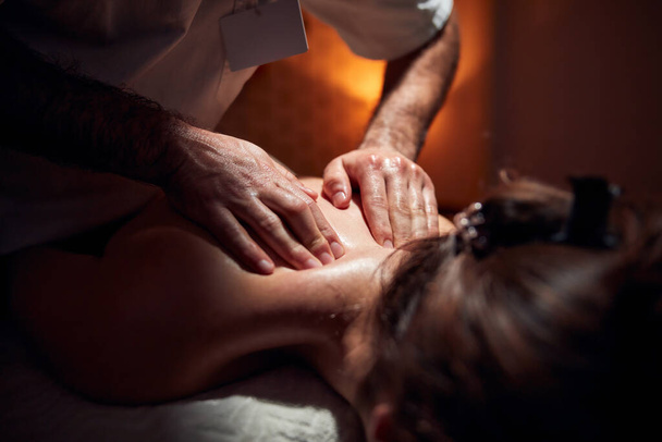 Woman on a massaging, chiropracting table, treatment of body and skin tension. - 写真・画像