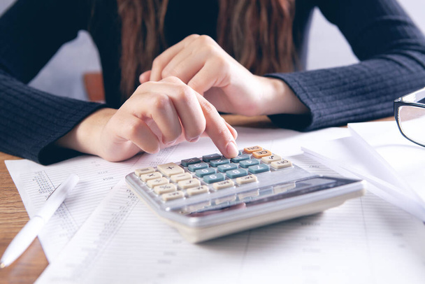young woman counting on a calculator - Foto, Bild