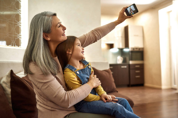 Woman and cute girl taking selfie at home - Fotoğraf, Görsel