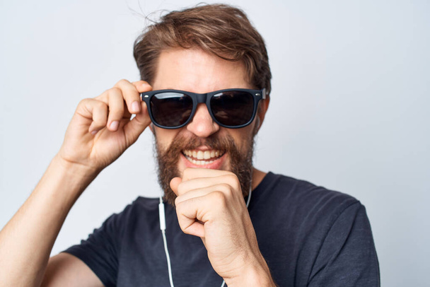 hombre barbudo en una camiseta negra música en el movimiento de los auriculares fondo aislado - Foto, imagen