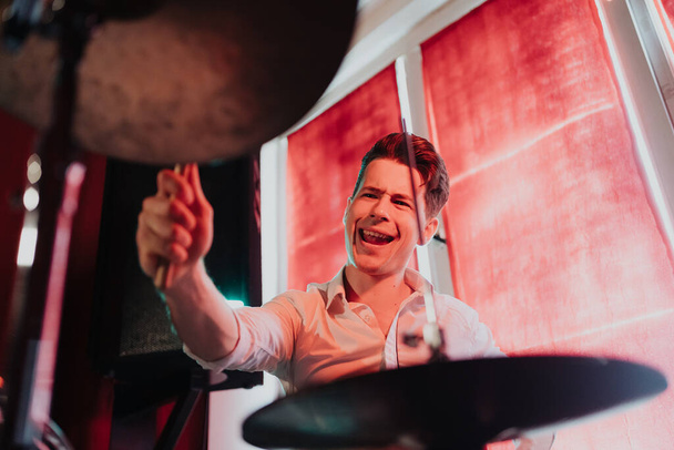 Schöner talentierter Kerl spielt Schlagzeug und bereitet sich auf Konzert vor - Foto, Bild