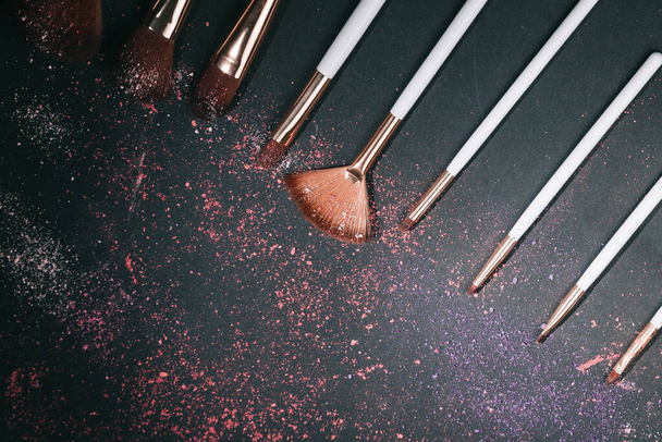 nine professional makeup brushes on a black background - Photo, image