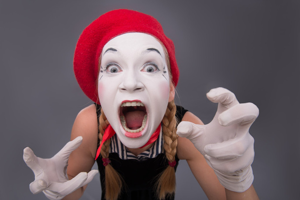 Portrait of female mime in red head and with white face isolated - Foto, Bild