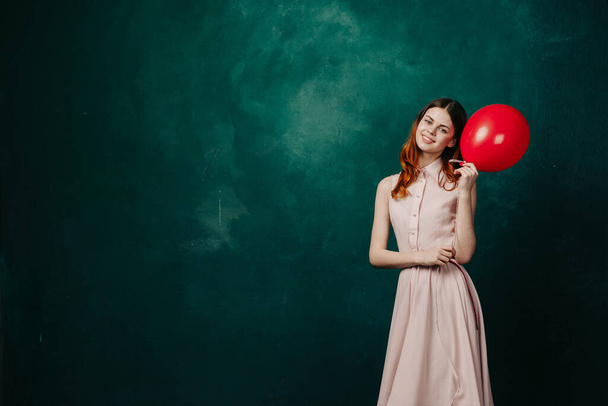 woman with red balloon on green background holiday fun - Photo, Image
