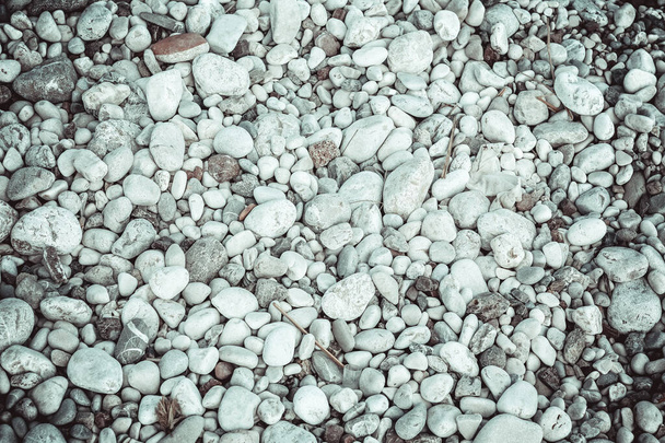 Zeekeien op het strand. Een close-up schot. Kleine en grote ronde gladde stenen. Textuur van het strand kiezelstenen voor een post, screensaver, behang, ansichtkaart, poster, banner, omslag, header voor een website - Foto, afbeelding