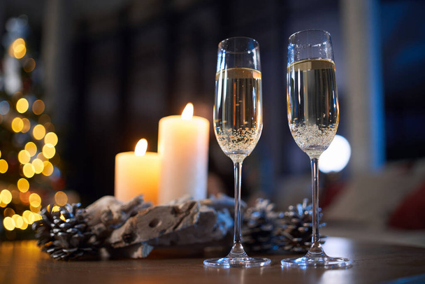 Glasses of champagne standing on table with christmas decor - Foto, Imagem