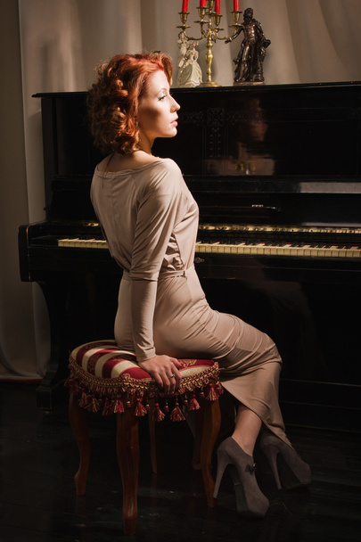 schoonheid vrouw in avondjurk pianospelen - Foto, afbeelding