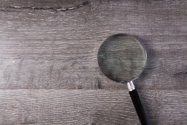 magnifying glass on a wooden table - Fotoğraf, Görsel