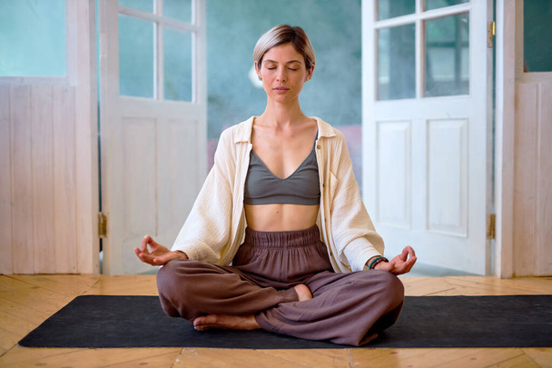 Meditation, Healthy Lifestyle. Caucasian woman sitting in padmasana lotus position - Zdjęcie, obraz