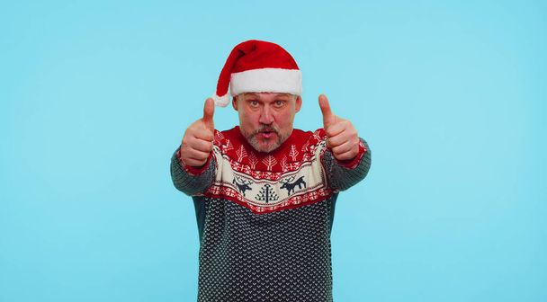 Αστείος άνθρωπος φοράει κόκκινο πουλόβερ Πρωτοχρονιάς με ελάφια ανυψώνει τους αντίχειρες επάνω συμφωνεί με κάτι καλό, όπως - Φωτογραφία, εικόνα