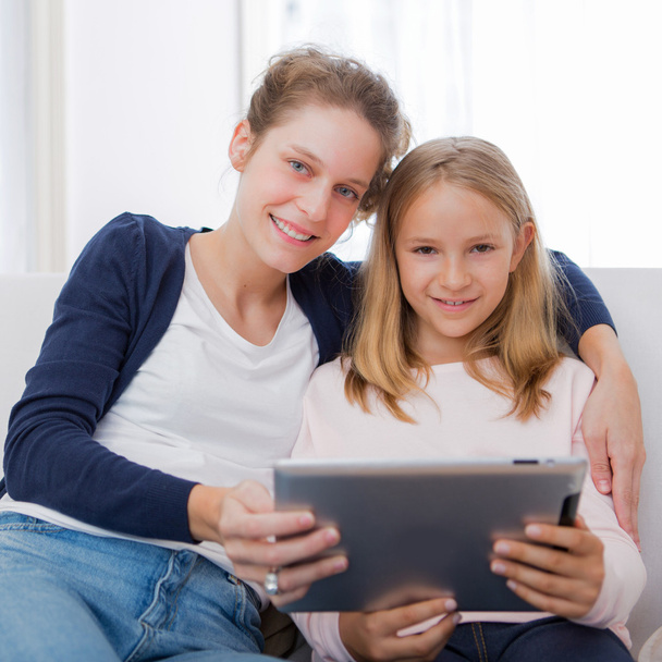 Attractive woman and little sister using tablet - Fotó, kép