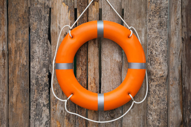 Orange life buoy hanging on wooden wall - Foto, immagini