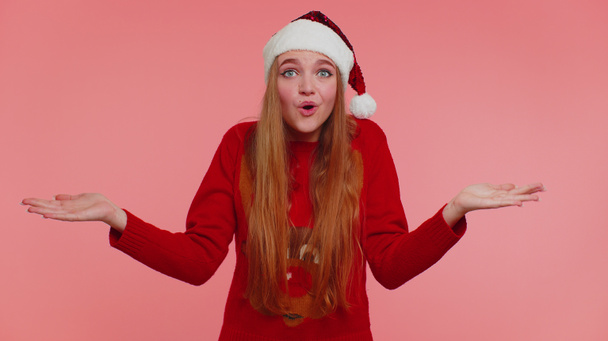 Összezavarodott lány karácsonyi pulóverben zavarban érzi magát a kétértelmű kérdés miatt, akinek fogalma sincs róla. - Fotó, kép