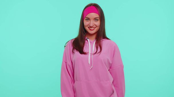 Joyful mooie een tiener student meisje mode model in roze hoodie glimlachen en kijken naar camera - Foto, afbeelding