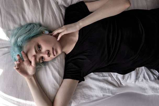 top view on upset female lying on bed, depressed upset woman at home alone - 写真・画像