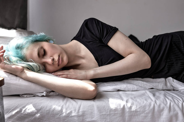 Unhappy exhausted woman lying on bed, suffering from headache or migraine - Foto, Bild