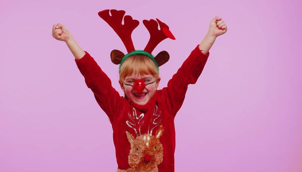 Веселая девочка в свитере Рождество Санта кричит, празднуя успех, победы, цели достигаются - Фото, изображение